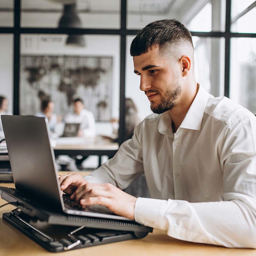 Jovem trabalhando no computador com mercado de trabalho e consumo