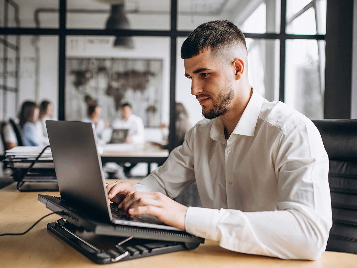 Jovem trabalhando no computador com mercado de trabalho e consumo